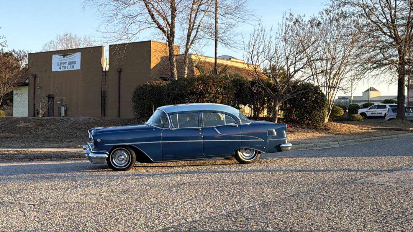 Blue 1955 Oldsmobile Super Rocket 88 parked on a street