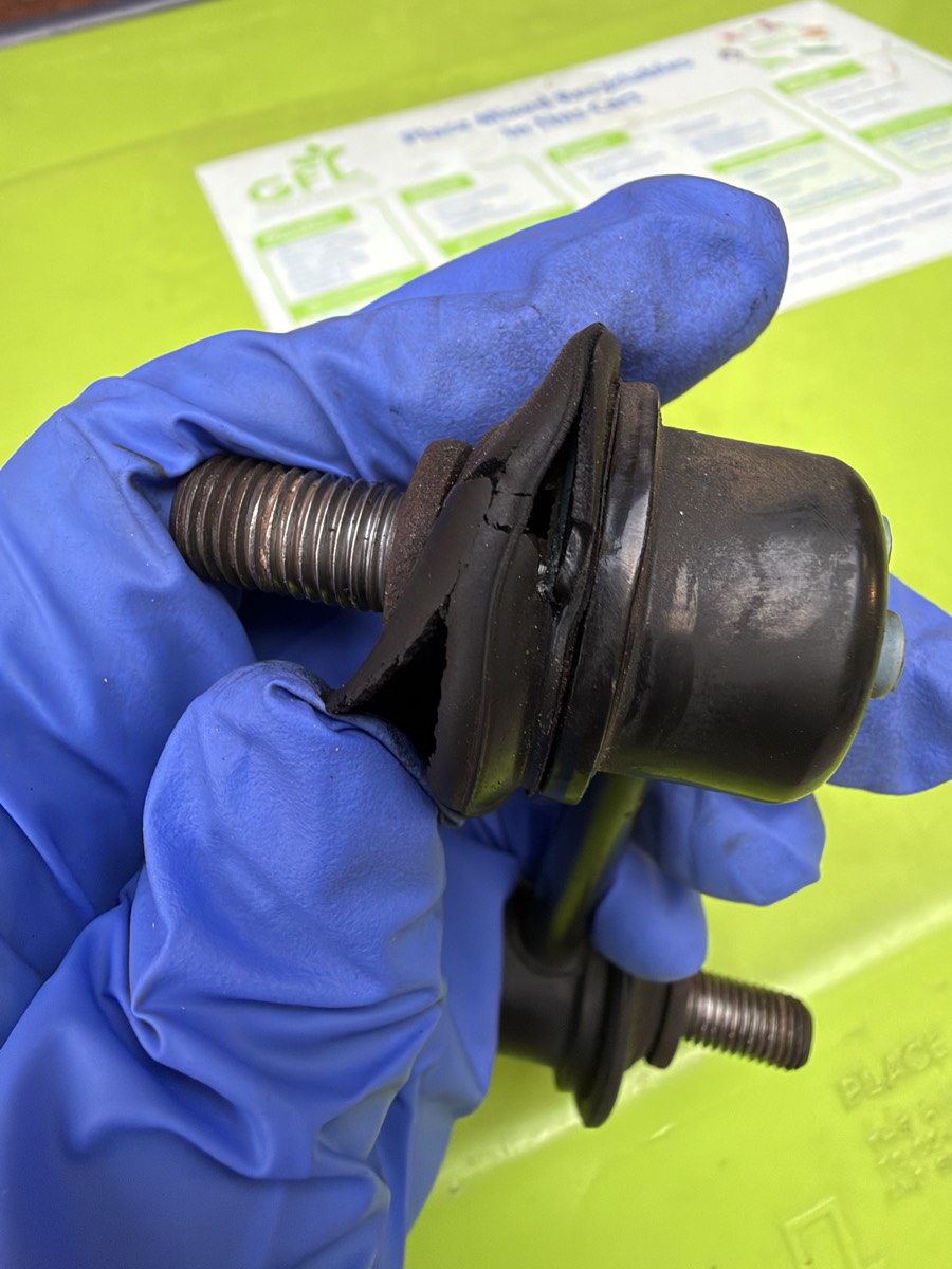 An old sway bar endlink, showing a cracked rubber boot